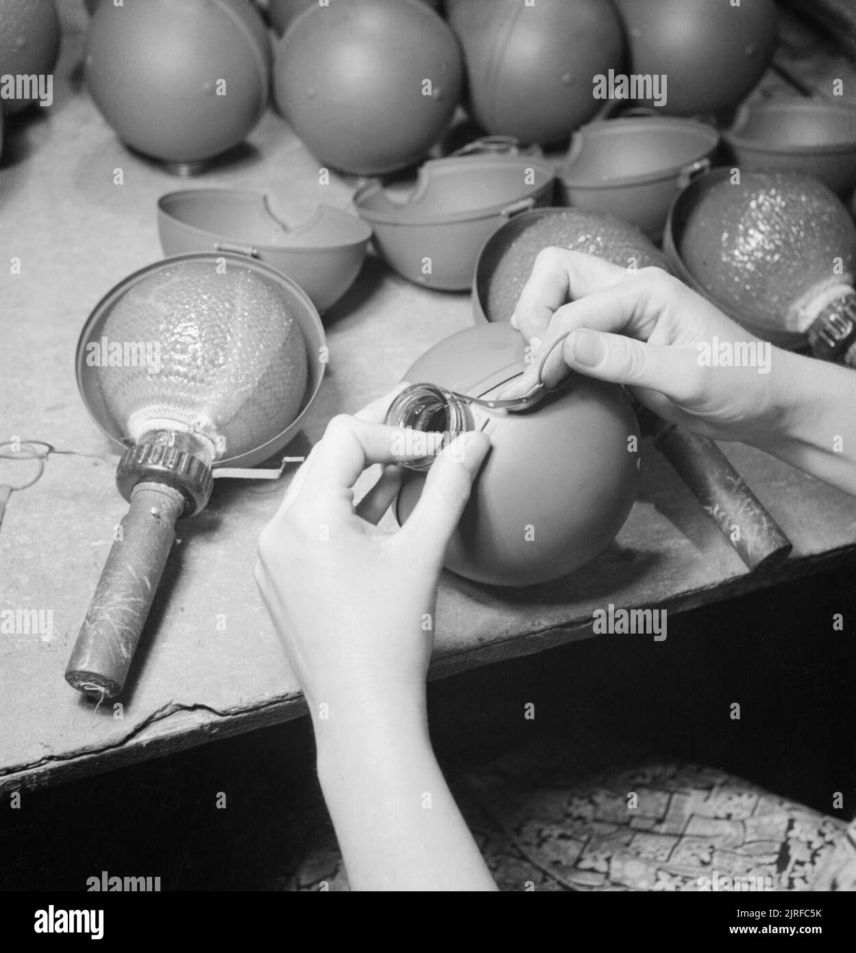 L'involucro protettivo è fissato in posizione intorno alla fiasca di vetro di una granata No.74, nota come una "bomba scattante" in un laboratorio in Gran Bretagna nel 1943. Foto Stock
