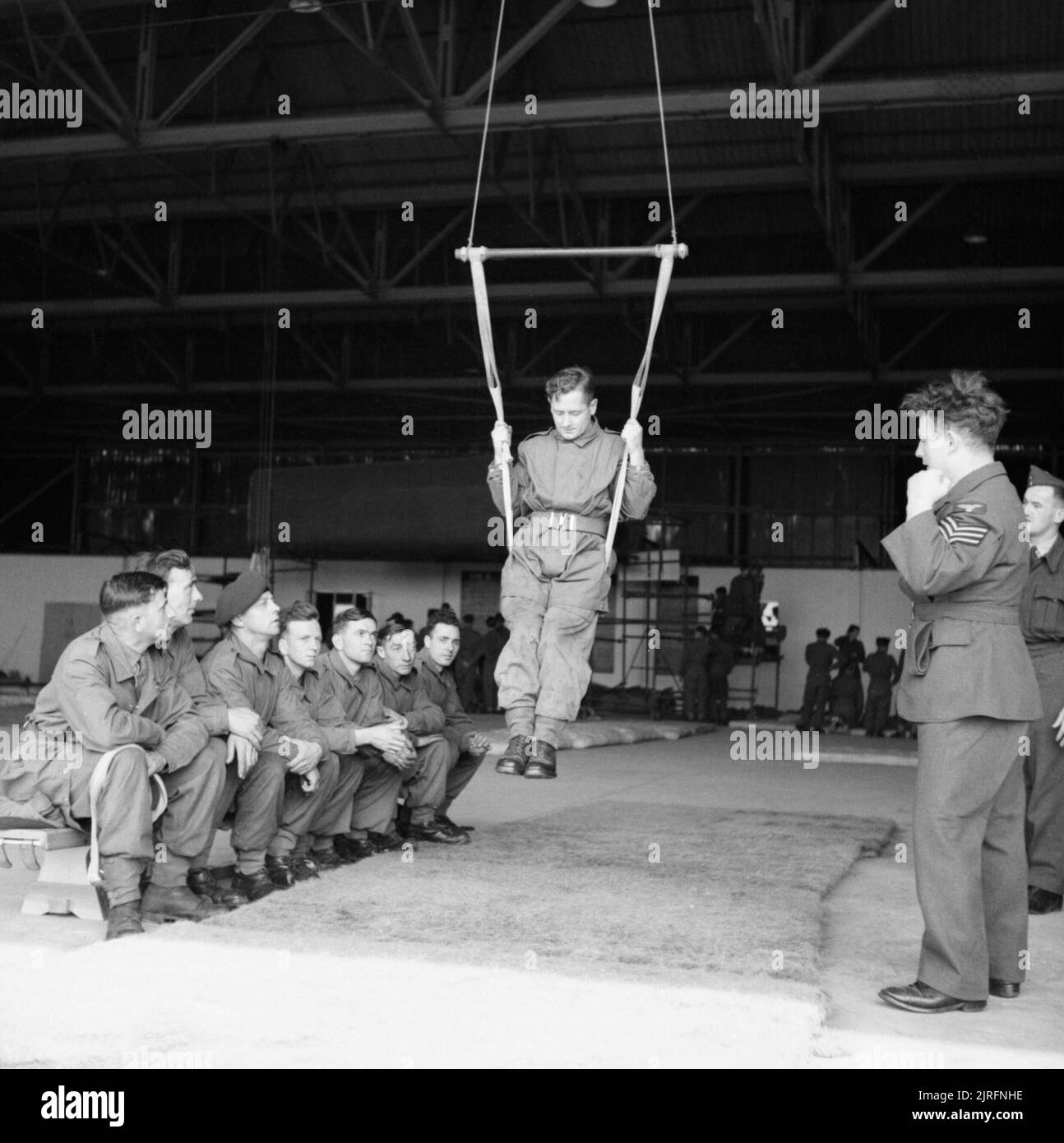 Paracadutisti imparare a terra correttamente utilizzando un cavo speciale a RAF Ringway, Agosto 1942. All'interno di un hangar, un paracadutista impara a terra correttamente utilizzando un cavo speciale. Foto Stock