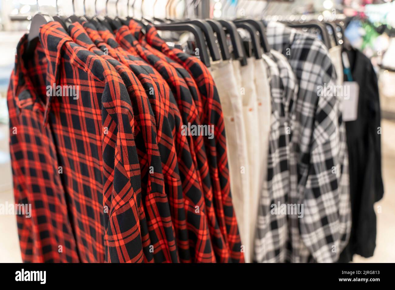nuove camicie a plaid con maniche corte su un appendiabiti in un negozio di abbigliamento Foto Stock