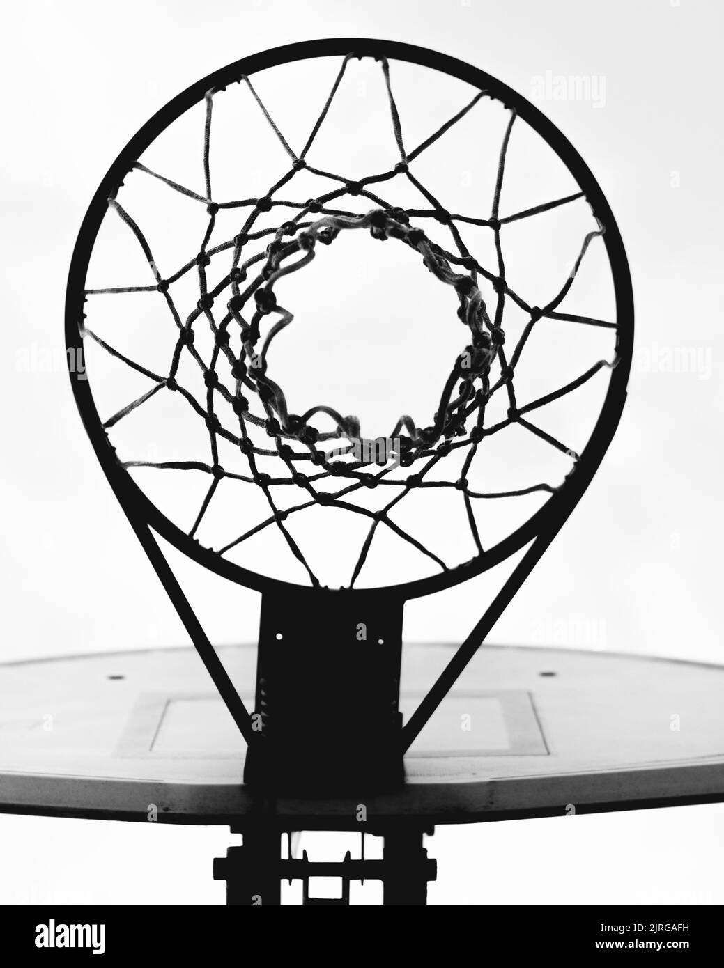 Un tiro verticale in scala di grigi del canestro da basket contro il cielo Foto Stock