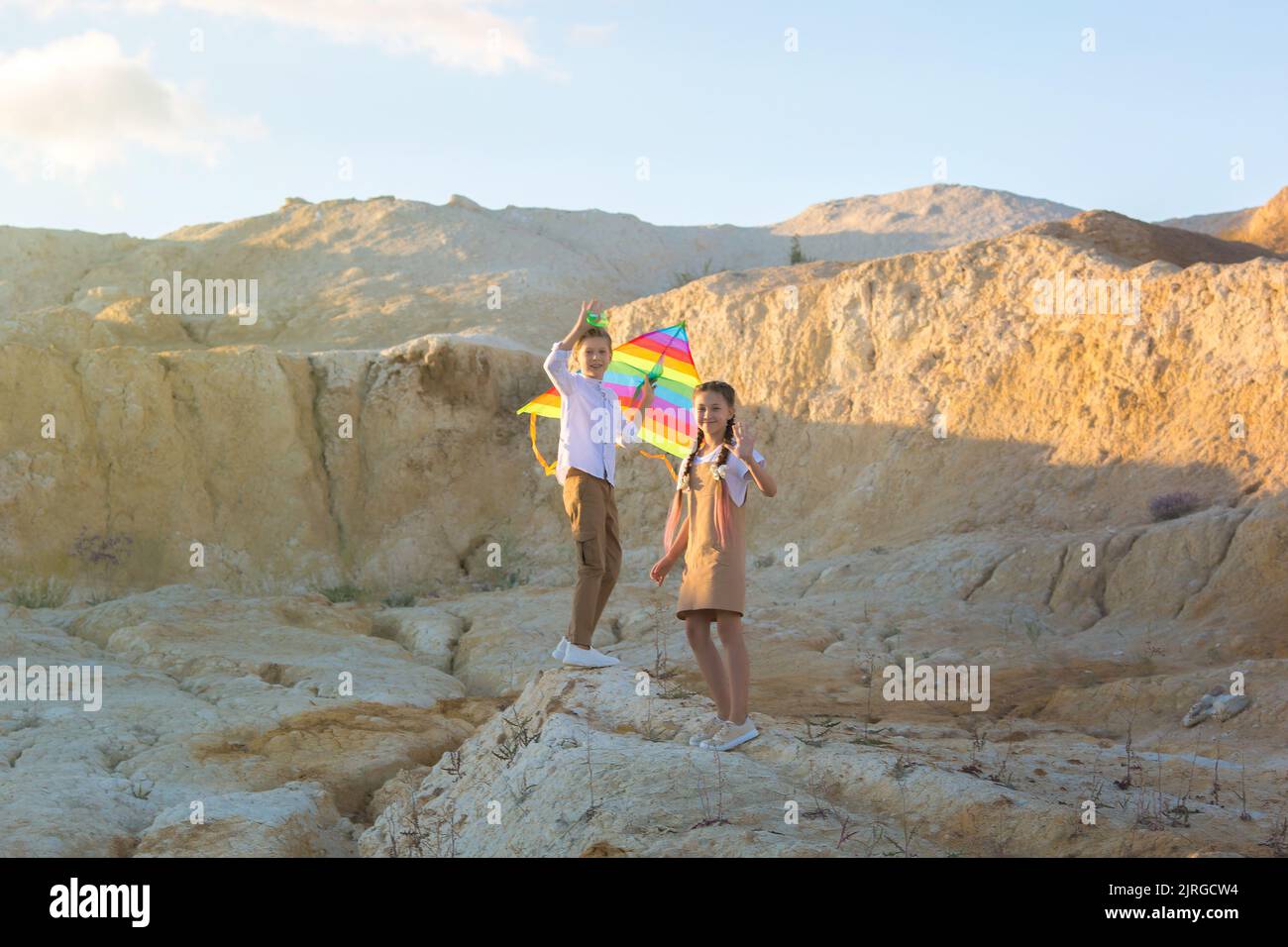 I bambini, ragazzi e ragazze, con un aquilone in mano salgono su un'alta montagna. Foto Stock