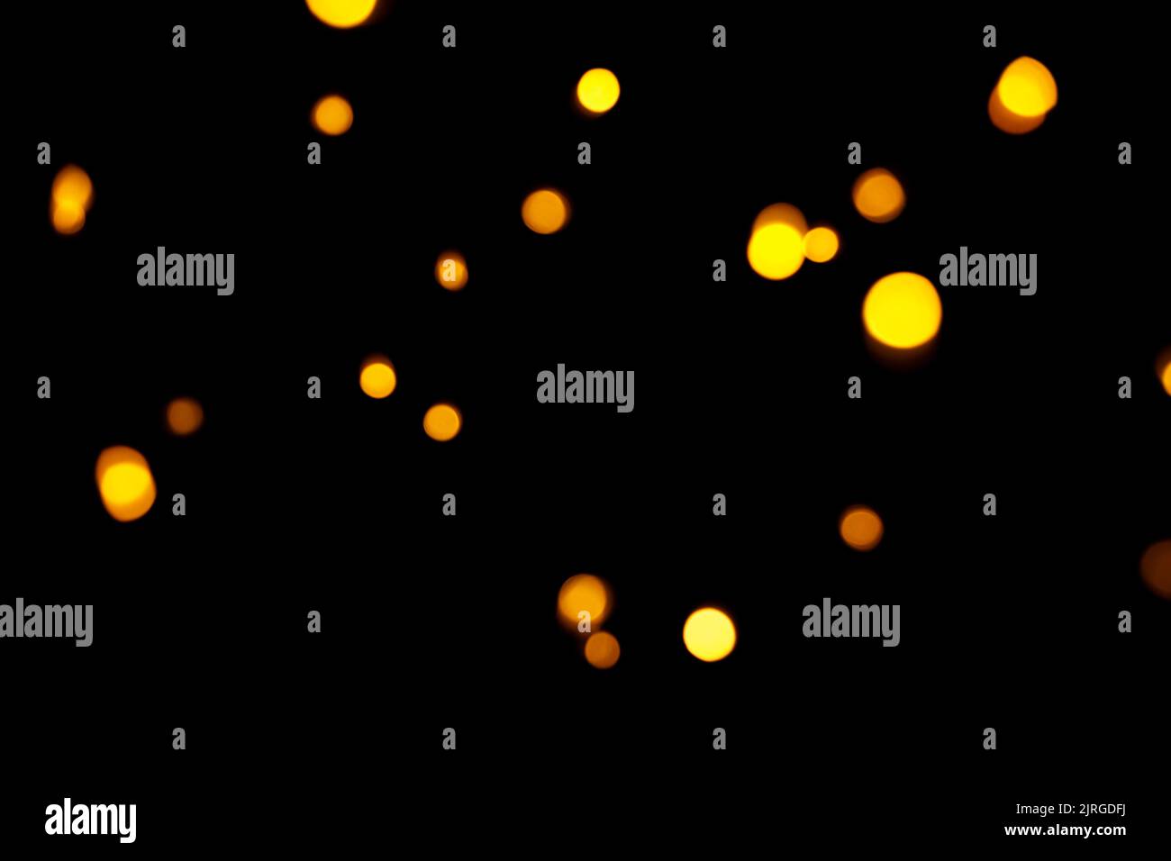 Oro bokeh su sfondo scuro. Luci dorate sfocate. Anno nuovo, sfondo natalizio, trama astratta Foto Stock