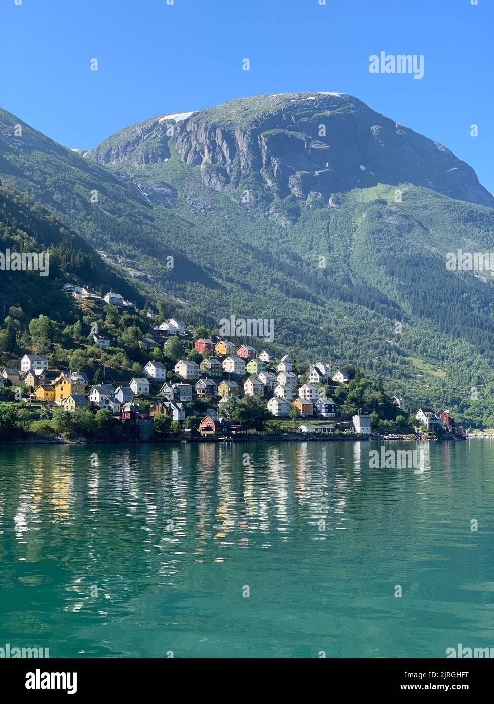 Uno splendido scenario di una piccola città costiera di Odda, Norvegia, con il sole Foto Stock