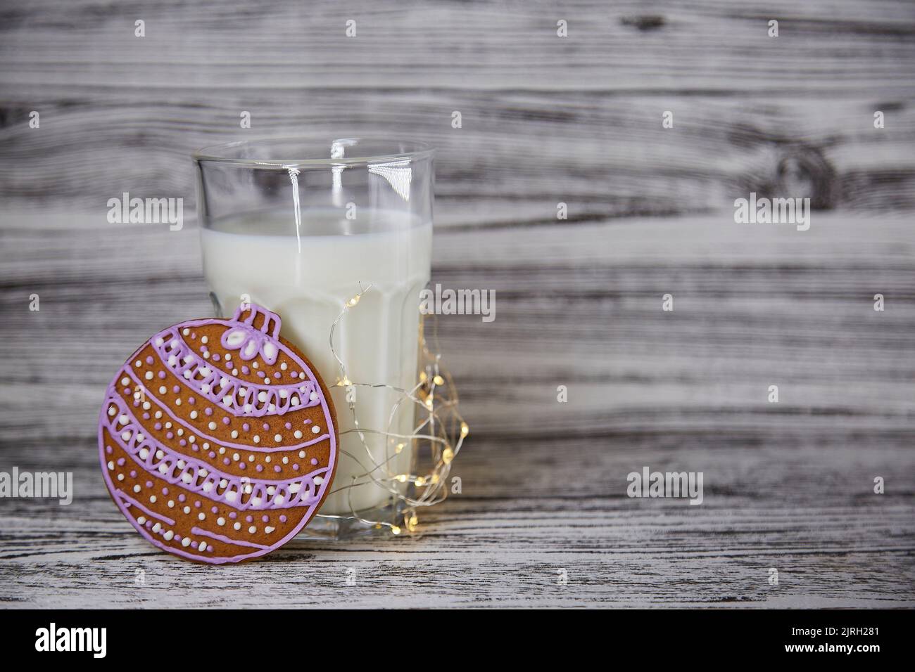 Latte con biscotti per Babbo Natale. Biscotti freschi fatti a mano e bicchiere con latte sul tavolo di legno d'annata. Tradizioni natalizie. Atmosfera estetica e sfondo natalizio festivo. Spazio di copia. Foto Stock