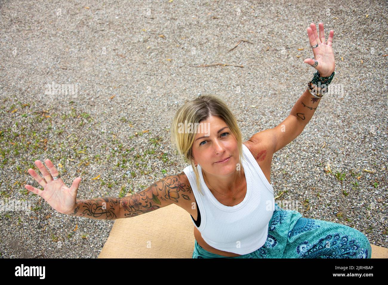 Giovane donna europea con braccia tese, con tatuaggi e piercing Foto Stock