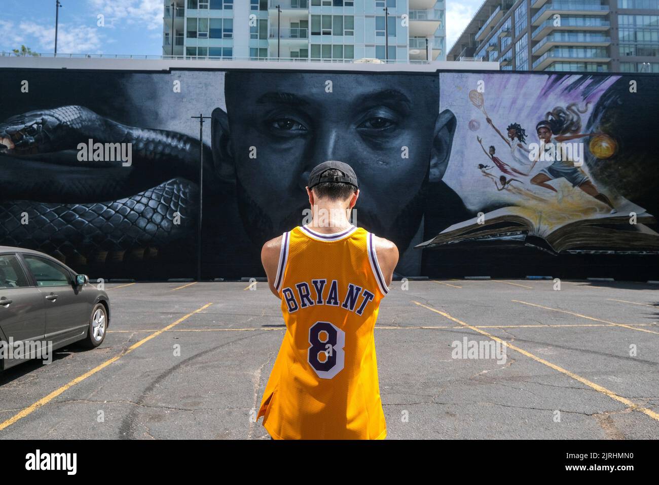 Los Angeles, California, Stati Uniti. 24th ago, 2022. Brian Tang indossa la maglia numero 8 di Los Angeles Lakers Kobe Bryant scatta delle foto un murale raffigurante Kobe Bryant e sua figlia, Gianna a Los Angeles, mercoledì 24 agosto 2022. Per segnare Mamba Day 2022, un murale gigante all'aperto di 125 piedi per 32 piedi che raffigura un primo piano del volto di Kobe Bryant, in bianco e nero, al centro, fiancheggiato da un serpente di mamba sulla sinistra e, a colori, Un gruppo di bambini, tra cui Gianna, figlia di Bryant, che gioca a basket in cima a un libro gigante, viene svelato su un intero lato di un edificio vicino all'ex Staples Center. (Credit IMA Foto Stock