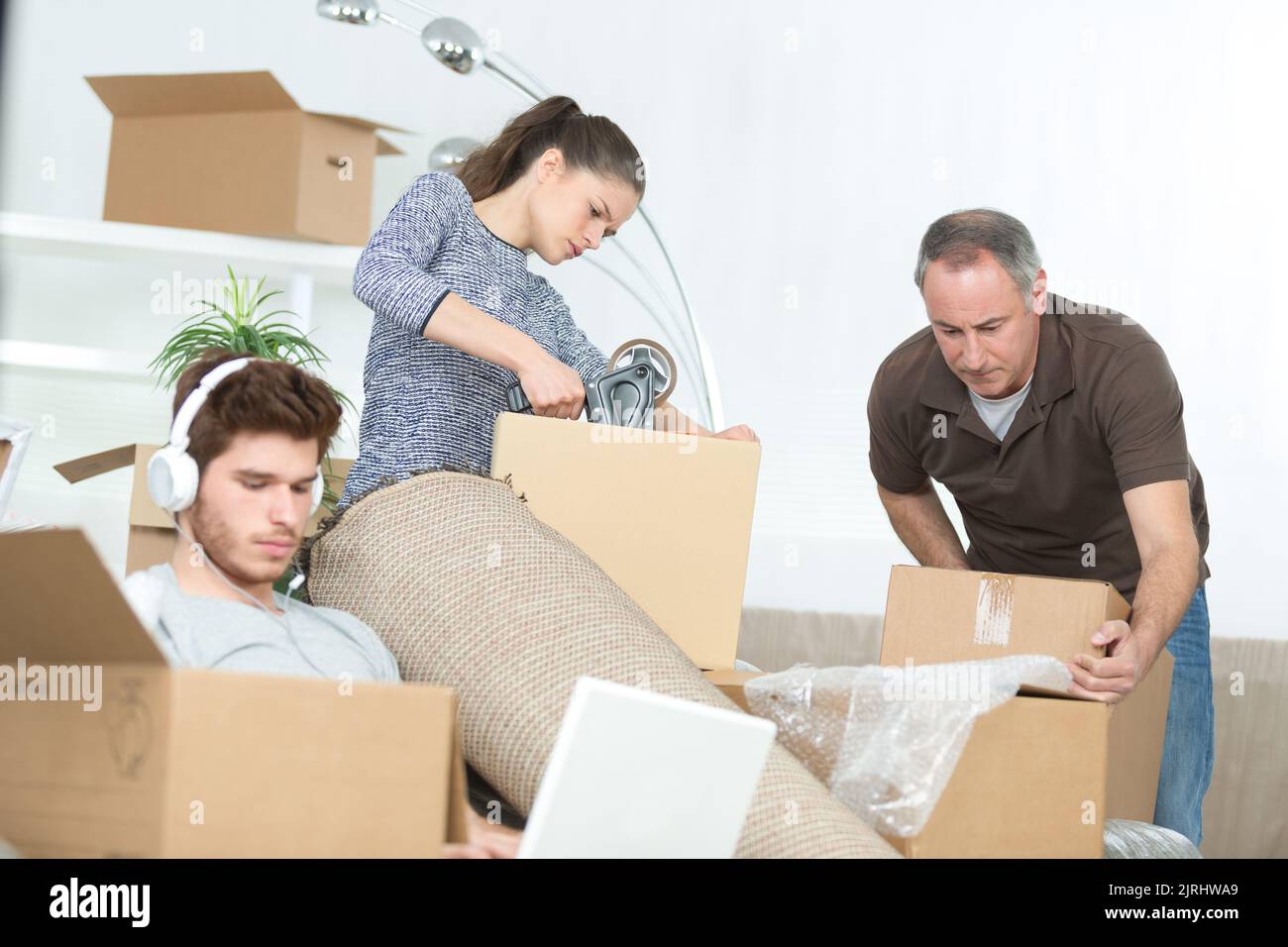 famiglia preparare scatole di cartone inattivo ragazzo sul computer portatile Foto Stock