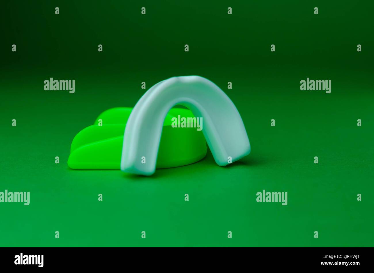 due protezioni in gomma per bocca, bianche e verdi, protezione per labbra e denti, concept Foto Stock