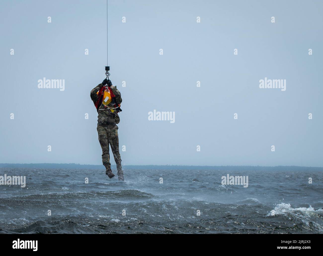 Uno studente di Survival, Evasion, Resistance and Escape del 492nd Special Operations Wing viene issato dalle acque vicino alla base dell'aeronautica militare di Eglin, Florida, 16 agosto. Gli Airmen hanno completato la loro parte di addestramento DI SERE per la sopravvivenza dell'acqua con l'aiuto del sistema di sollevamento UH-1 Huey di 413th Flight Test Squadron. L'UH-1 sollevò ogni studente dall'acqua sollevandoli verso il basso e poi di nuovo verso il basso. (STATI UNITI Foto dell'aeronautica/Samuel King Jr.) Foto Stock