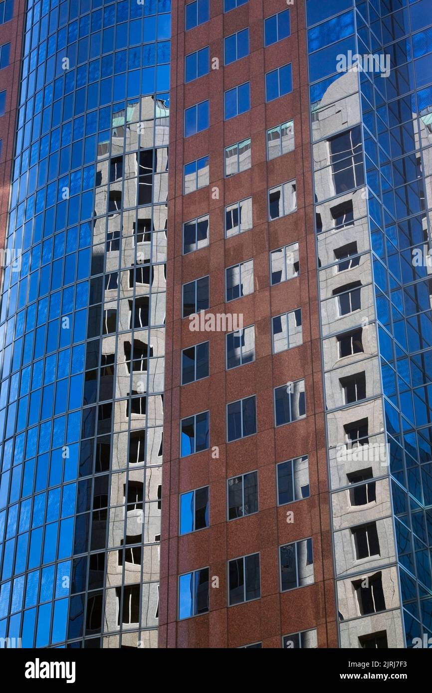 Si riflette in un moderno edificio d'uffici in stile architettonico in vetro e acciaio. Foto Stock