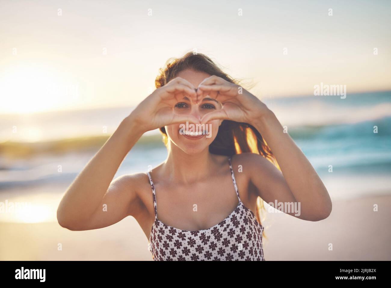 Guarda la natura con amore: Una giovane donna che si diversa in spiaggia. Foto Stock