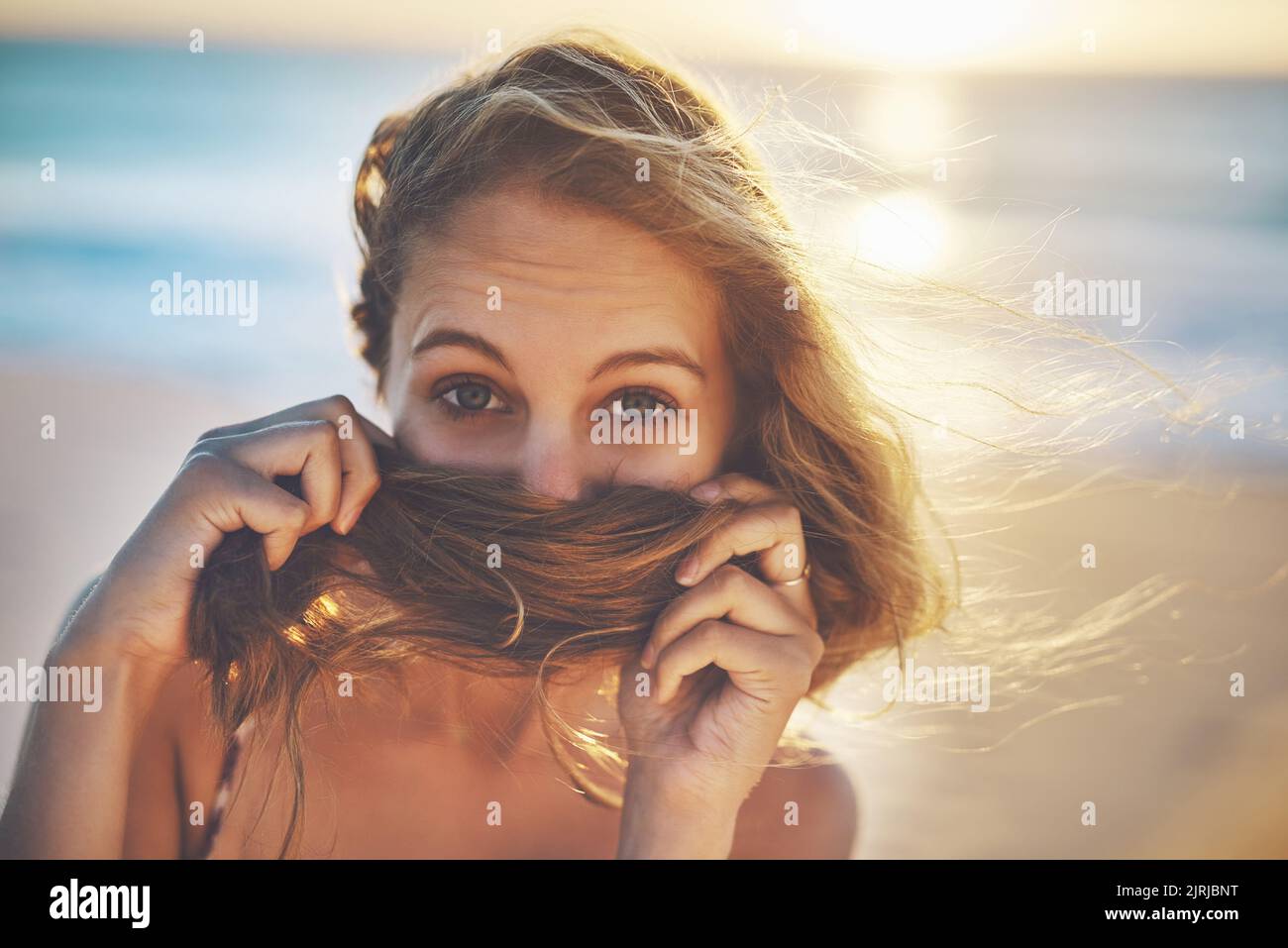 Adoro il profumo dei capelli da spiaggia, una giovane donna che copriva la bocca con i capelli. Foto Stock
