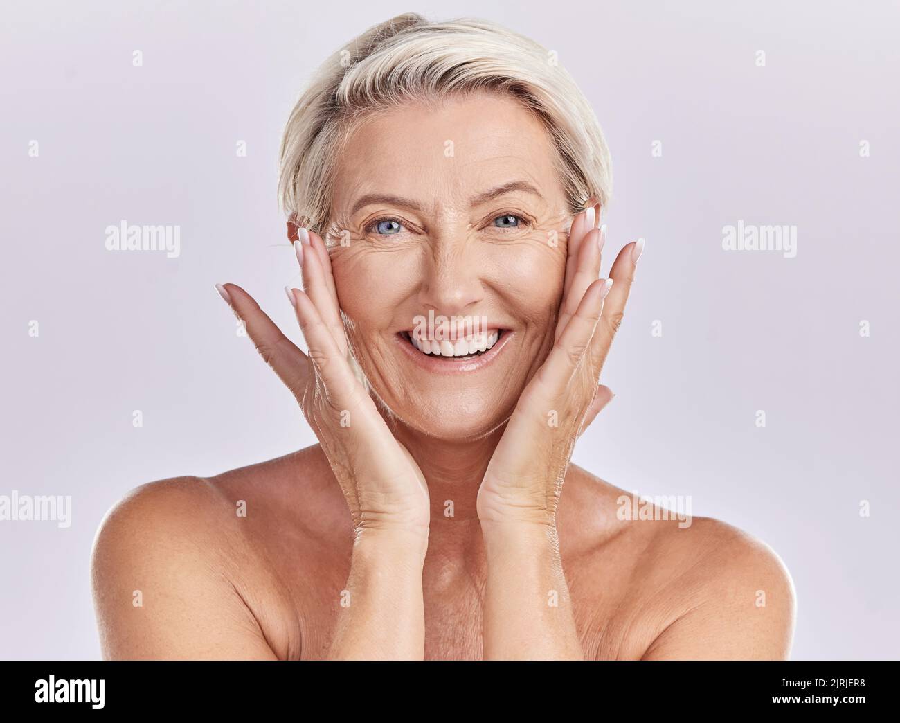 Ritratto di una donna felice viso sorriso con sana cura della pelle mentre si posa in uno studio contro sfondo viola mockup studio. Donna anziana che la fa Foto Stock