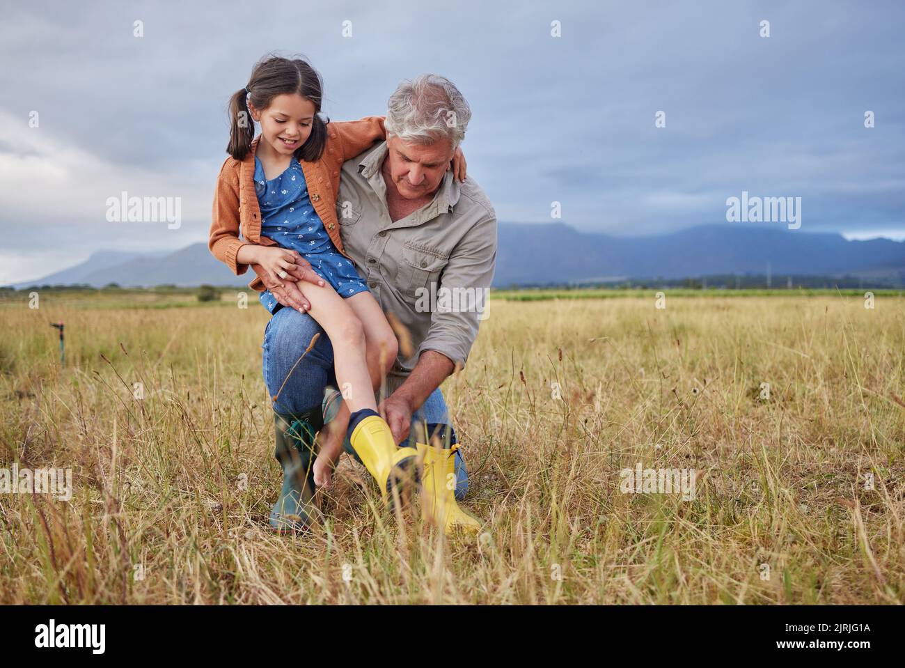 Felice legame di famiglia sul nonno fattoria e la ragazza divertirsi in natura, prepararsi per camminare insieme. Bambino sorridente e nonno premuroso esplorare Foto Stock