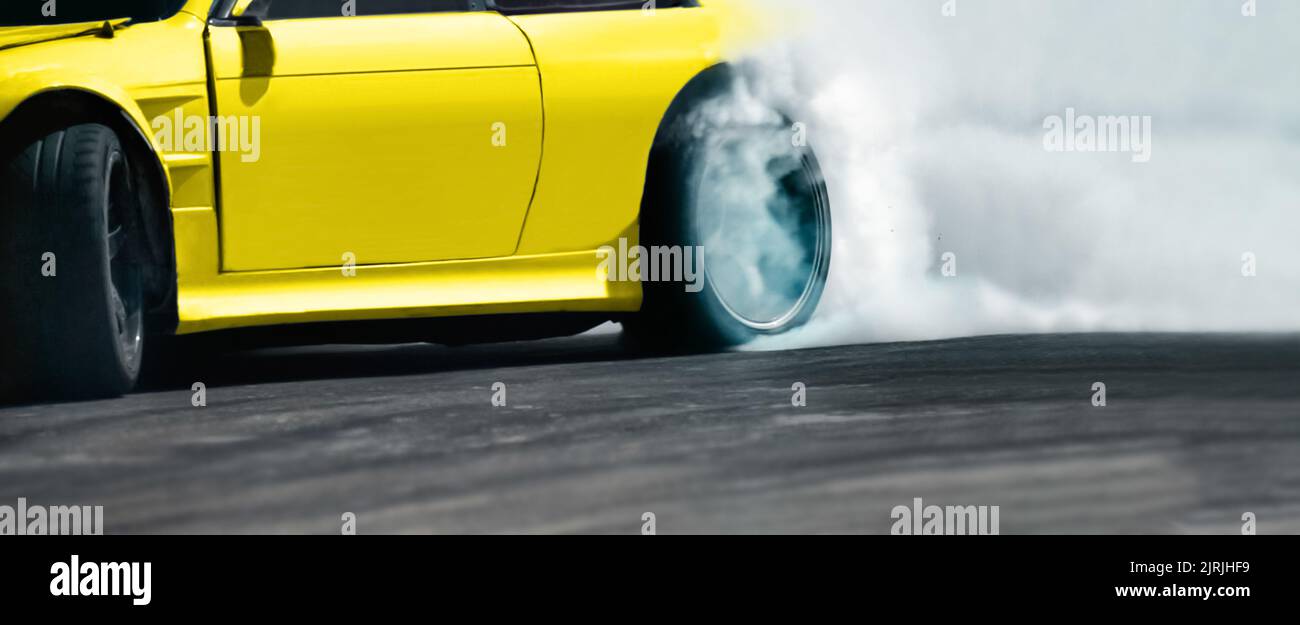 Auto da corsa che brucia pneumatici sulla pista di velocità Foto Stock