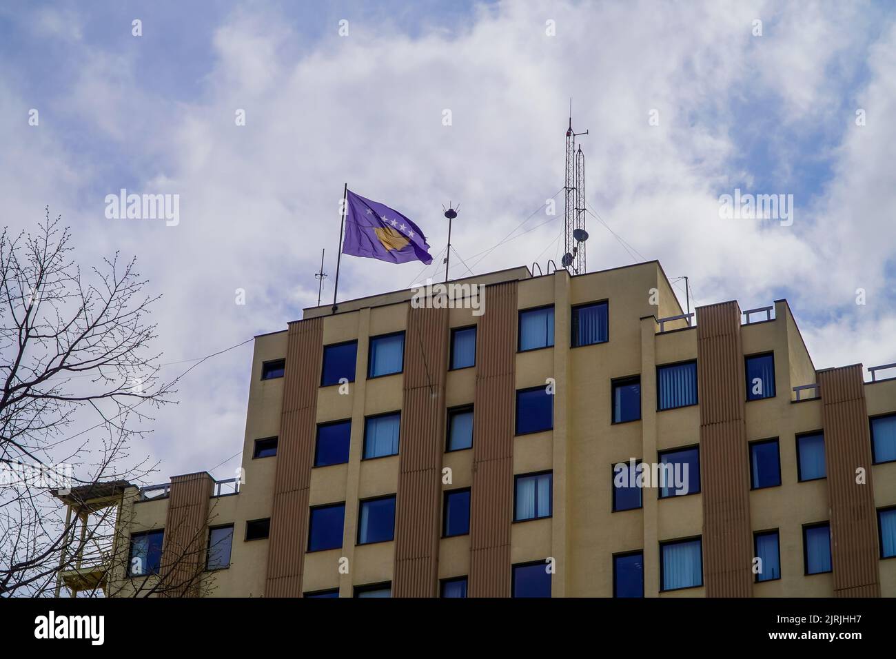 Un edificio con la bandiera del Kosovo in cima a Pristina Foto Stock