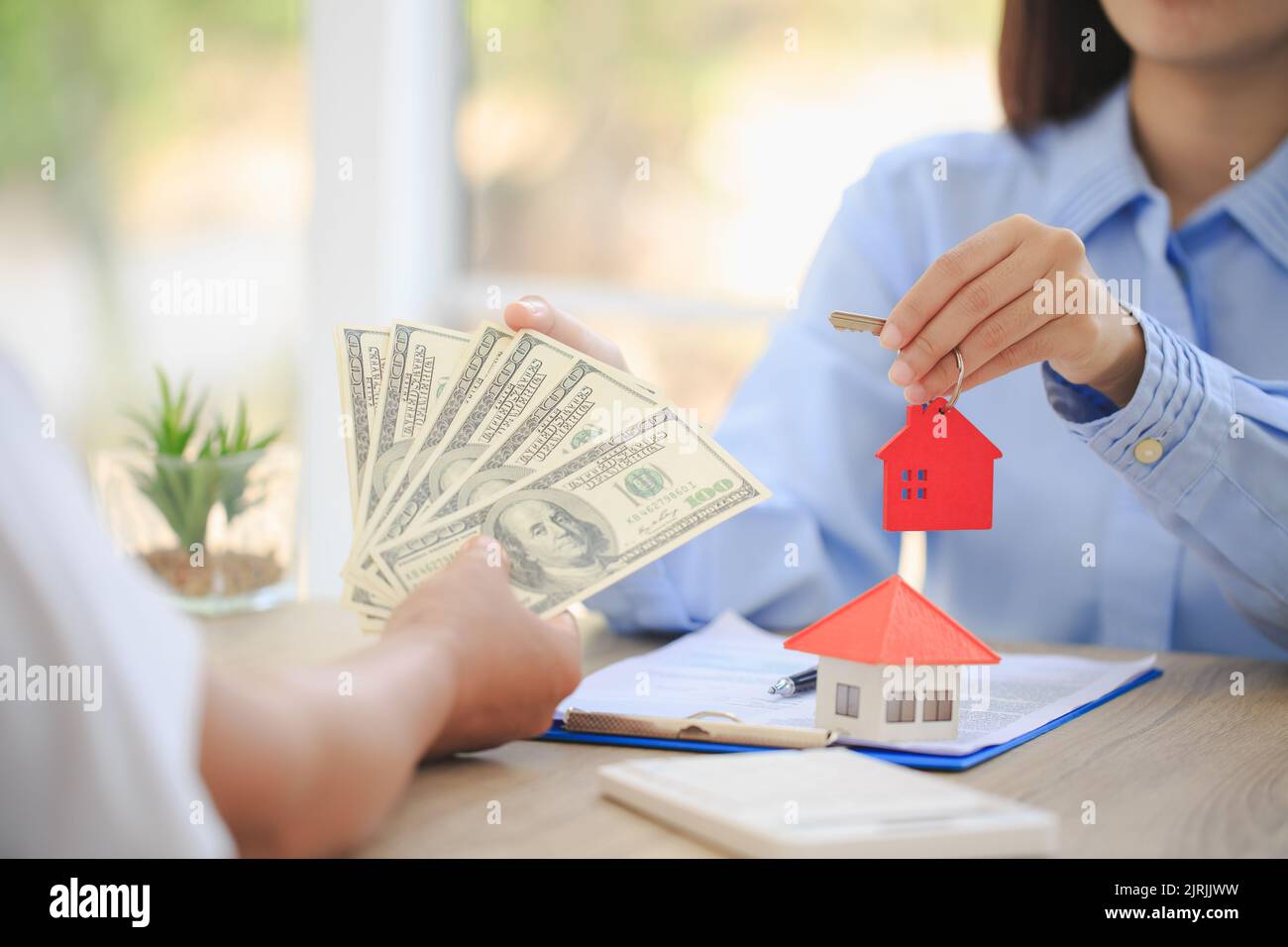 Un agente immobiliare con una chiave. Assicurazione sulla proprietà, scegliendo una casa in futuro. Ipoteche bancarie e domestiche. Foto Stock