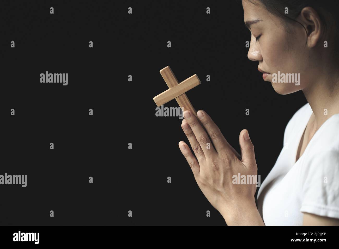 La ragazza che pregava a dio, entrambe le mani, afferrò la croce. Idee per Cristo. Cristianesimo. Religione cattolica. Sacra. Cielo. Pregate. Credete. Fede. Pregate. Desiderat Foto Stock