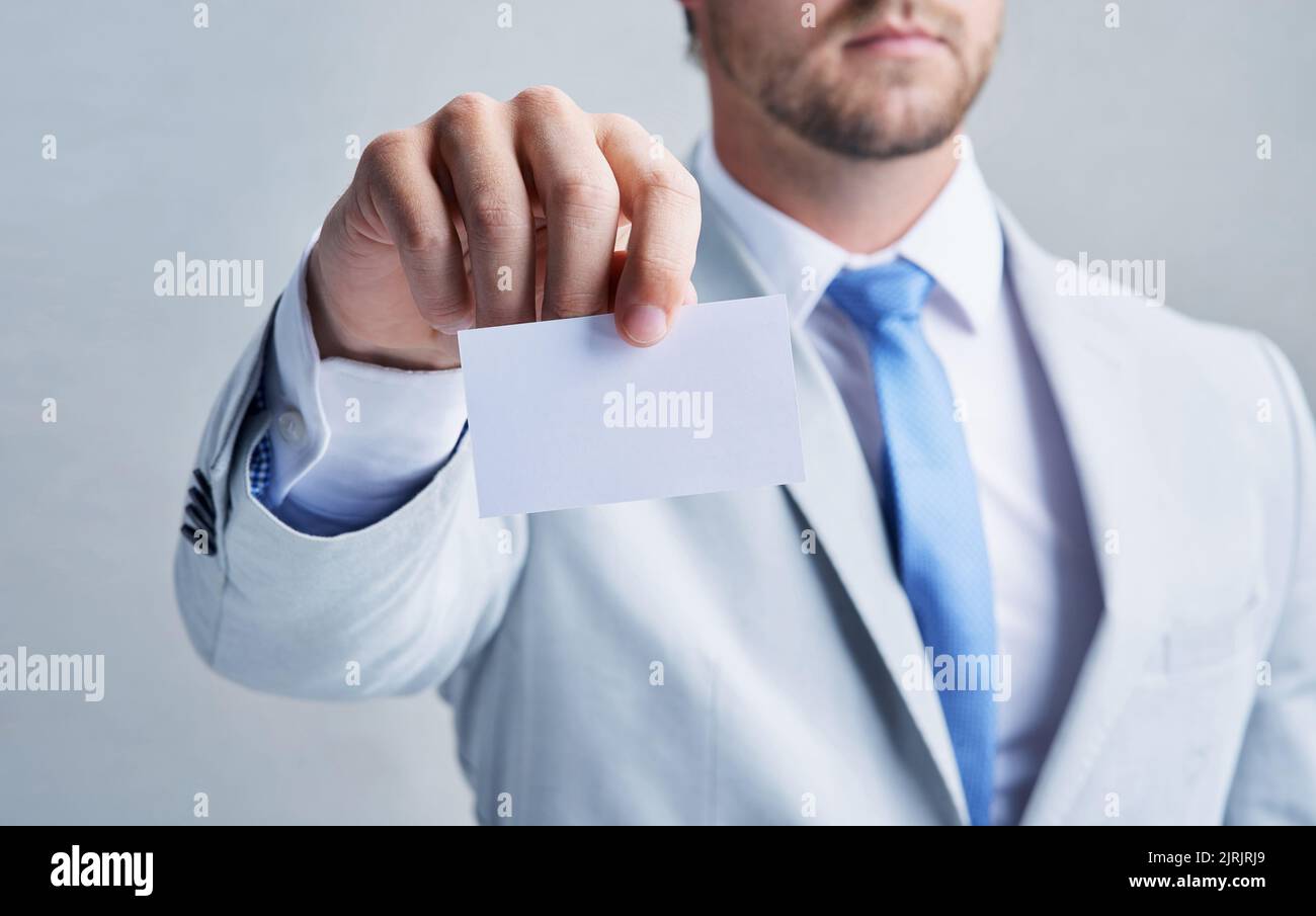 Im che vi dà qualcosa che non potete trovare dovunque altro. Studio shot di un uomo d'affari che tiene un biglietto da visita vuoto su uno sfondo grigio. Foto Stock