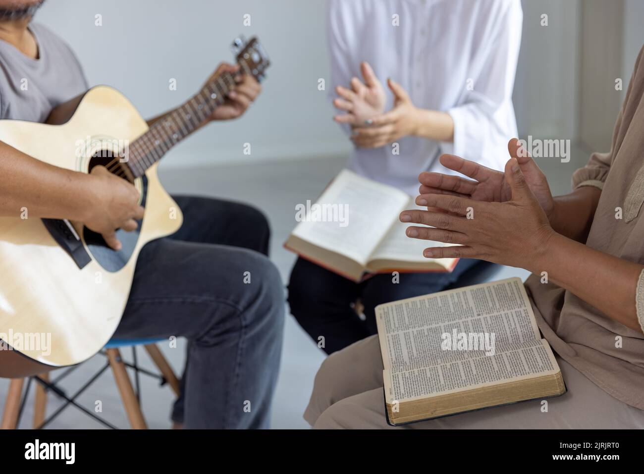Le famiglie cristiane adorano Dio nelle loro case. Per una vita rilassata per onorare Dio con belle interpretazioni di chitarra e scritture. Foto Stock