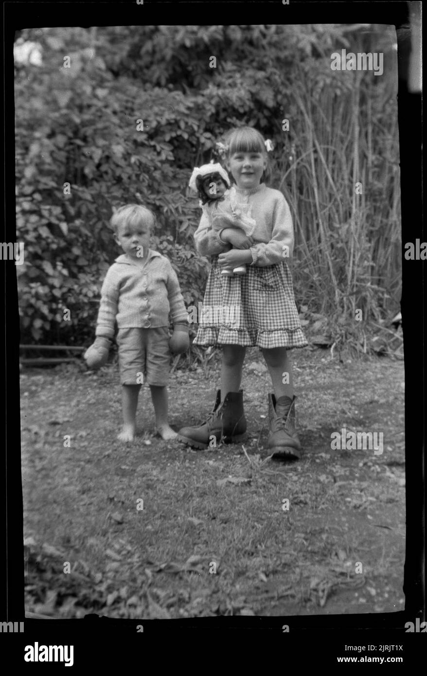 [Bambini in piedi in giardino], 1920s-1930s, Nuova Zelanda, di Roland Searle. Foto Stock