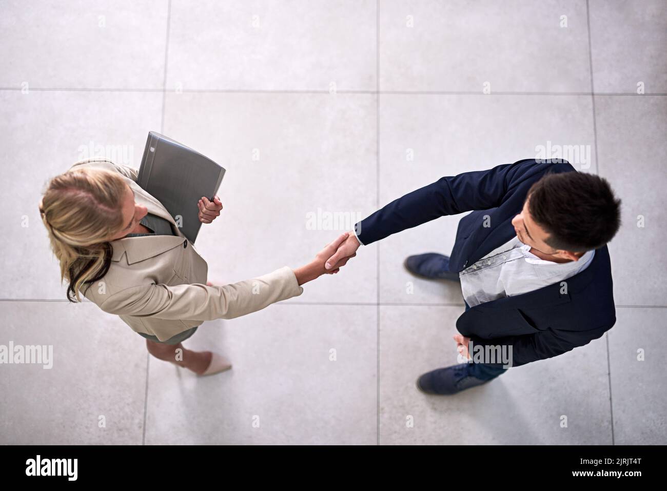 Bene faccia le cose grandi insieme. Inquadratura ad angolo alto di due uomini d'affari professionisti che scuotono le mani in ufficio. Foto Stock