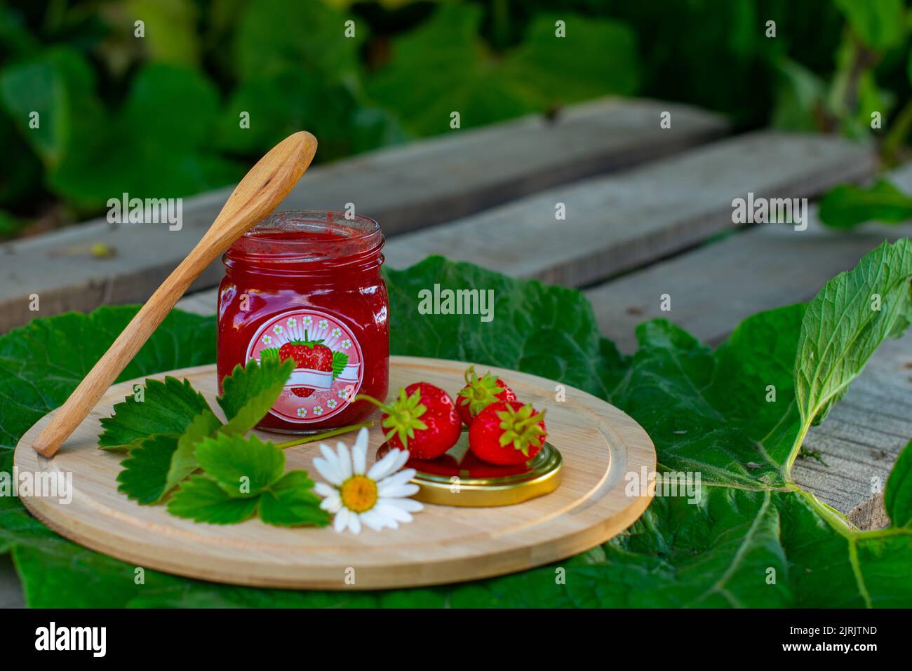 deliziose marmellate e bacche si trovano su un asse di legno Foto Stock