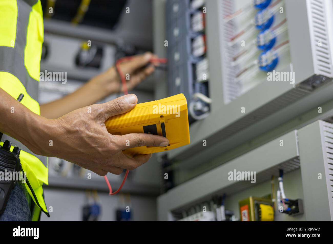 Tester di lavoro per elettricisti che misura la tensione e la corrente della linea elettrica di alimentazione nel controllo elettrico dell'armadio. Foto Stock