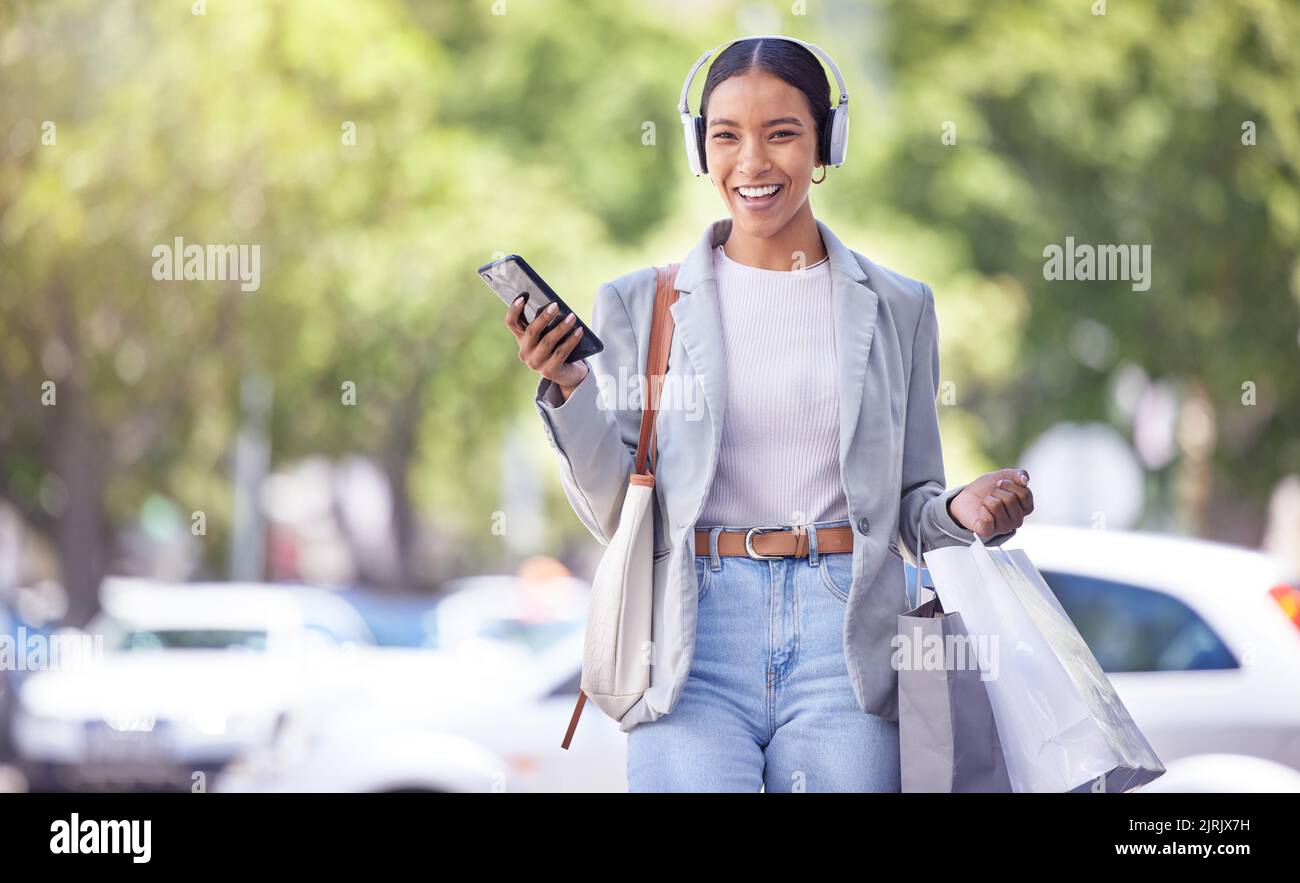 Shopping in città, donna con smartphone e cuffie ascoltare abiti moda podcast con sorriso sul volto per la vendita di marketing suggerimenti e di stile idea Foto Stock