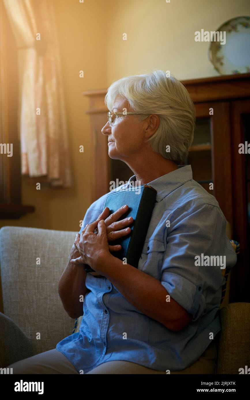 Mettete la vostra speranza nella sua parola: Una donna anziana che tiene a casa una Bibbia. Foto Stock