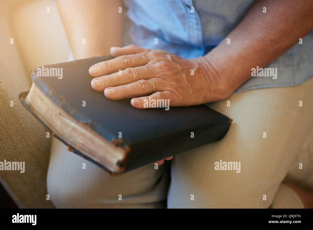 La parola contiene ogni speranza e conforto che cercate. Primo piano di una donna anziana in possesso di una Bibbia a casa. Foto Stock