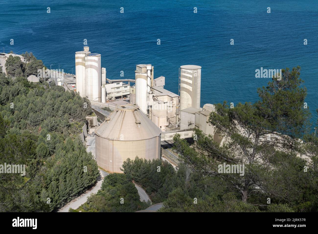 Vista di un'azienda produttrice di cemento di fronte all'oceano a Setubal, Portogallo. Foto Stock