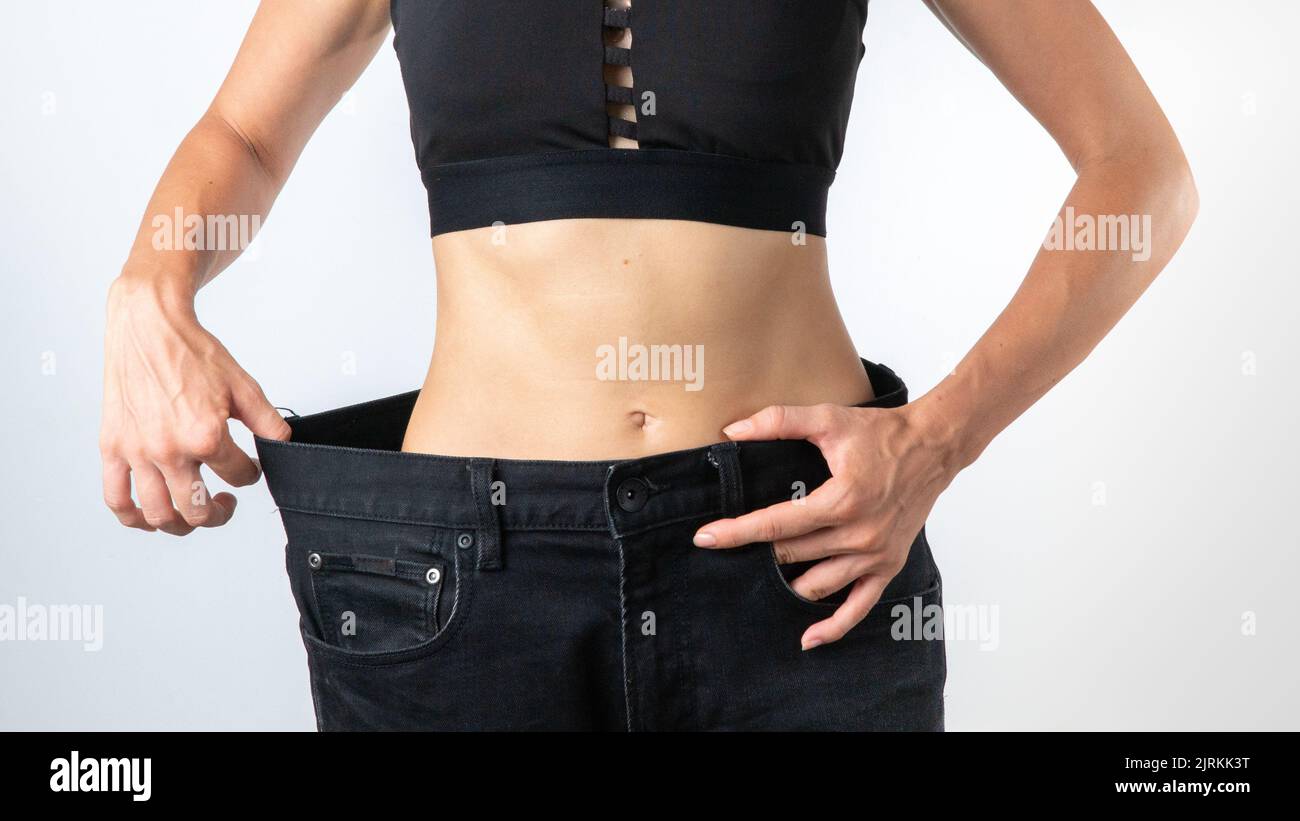 Una donna in pantaloni un formato più grande - perdita di peso, corpo sottile, dopo la dieta. Foto di alta qualità Foto Stock
