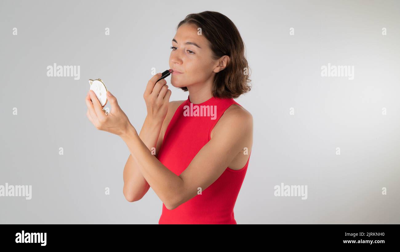 Trucco a casa - una donna le dipinge le labbra con rossetto. Foto di alta qualità Foto Stock