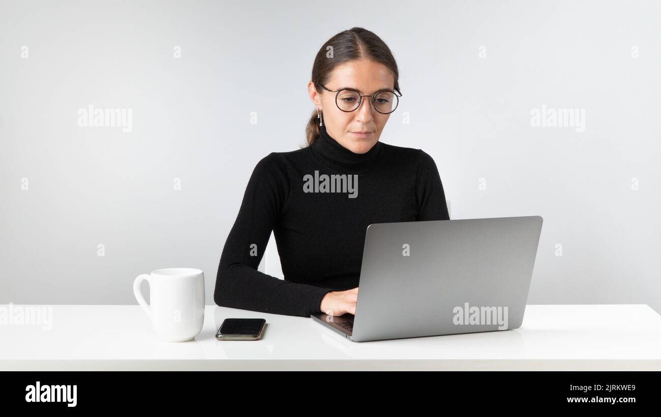 Una dipendente di un ufficio lavora in un computer portatile. Foto di alta qualità Foto Stock