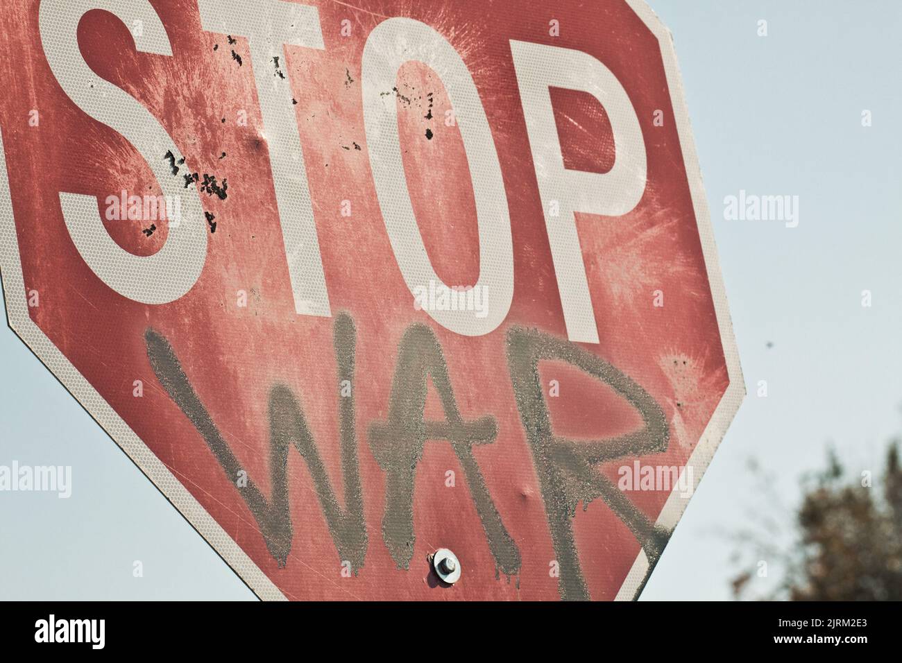 Segnale di stop dipinto a spruzzo con una protesta anti-guerra. Foto Stock