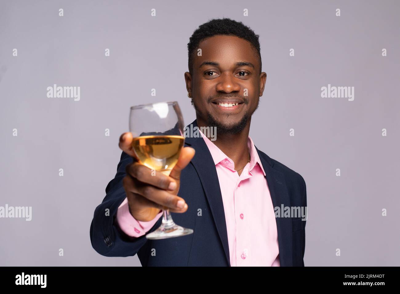 giovane uomo d'affari nero che alza un bicchiere Foto Stock
