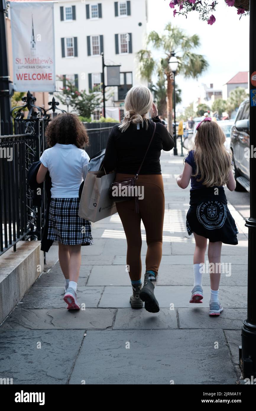 Una vista posteriore di tre femmine che camminano nella città di Charleston Foto Stock