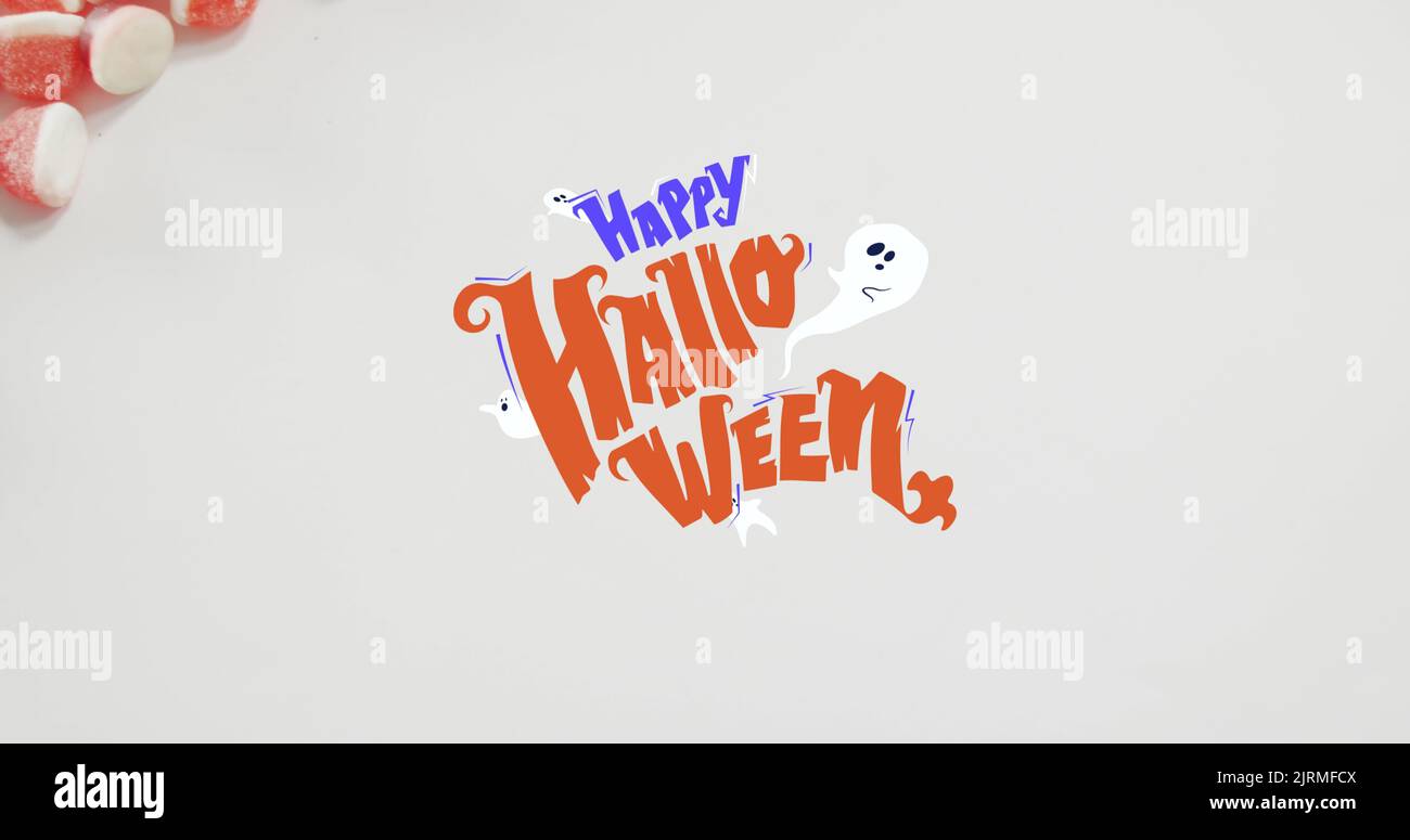 Banner di testo halloween felice e icone fantasmi contro il primo piano di cornici caramelle sulla superficie bianca Foto Stock