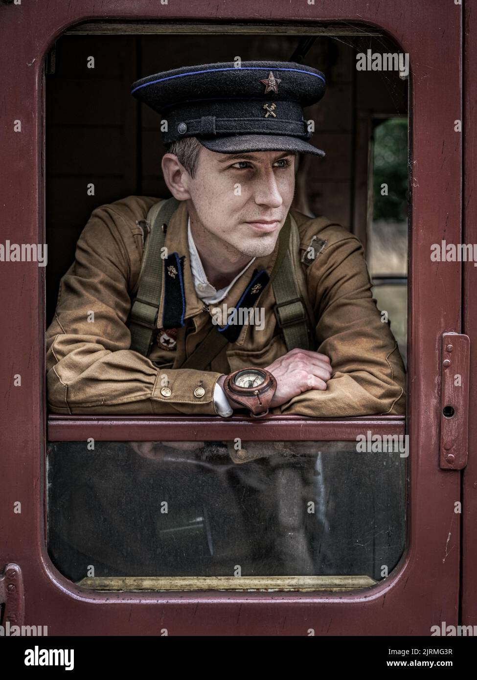 Un colpo verticale di un soldato russo reenactor in una carrozza trainabile guardando da parte. Rievocazione storica Foto Stock