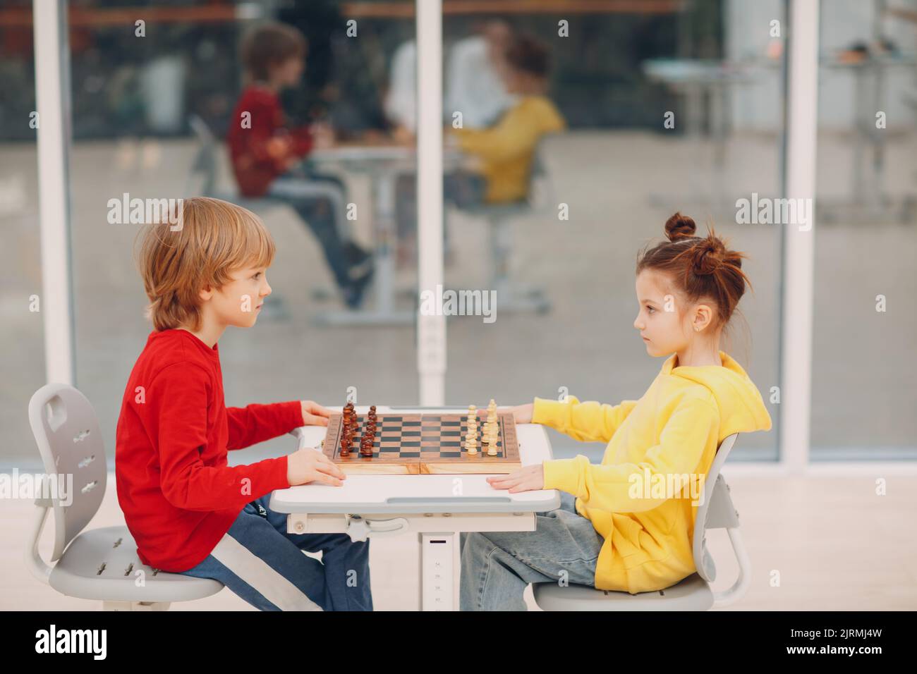 Bambini piccoli che giocano a scacchi all'asilo o alla scuola elementare. Gioco di scacchi per bambini Foto Stock