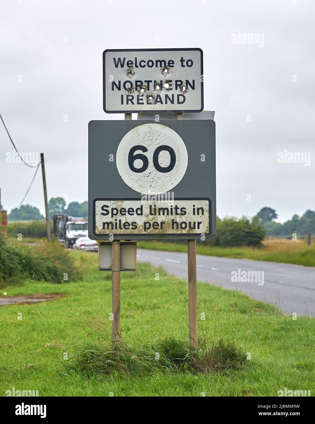 Un cartello di benvenuto in Irlanda del Nord pieno di grandi buche proiettili. Foto Stock