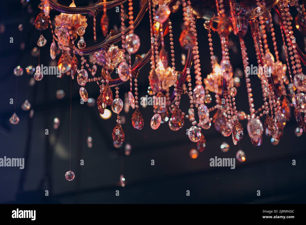 grande lampadario di cristallo illuminato con luce multicolore nel ristorante. Foto Stock