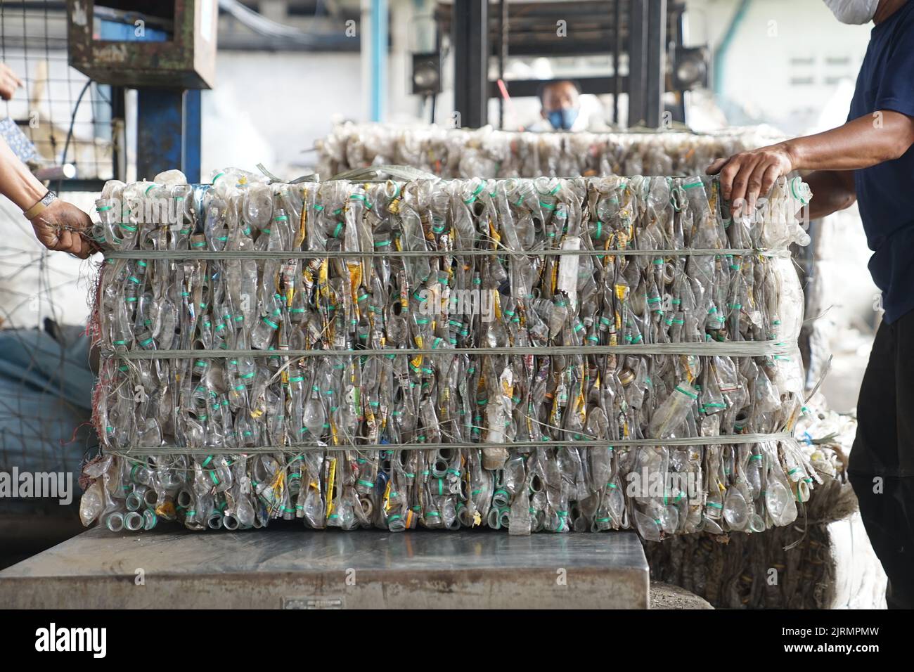 Due uomini in possesso di bottiglie di acqua minerale confezionate e pronte per il riciclo Foto Stock