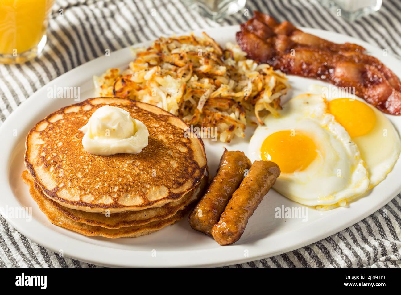 Brunch con colazione all'americana con frittelle fatte in casa con uova, pancetta e hashbrown Foto Stock