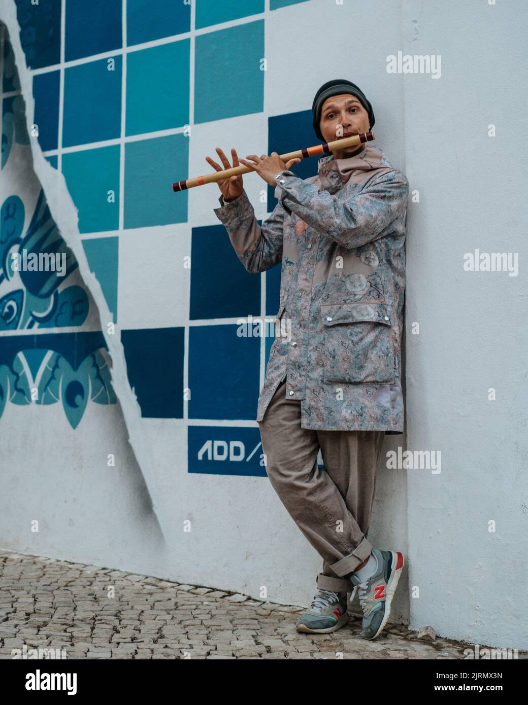 Un giovane maschio russo che suona un flauto di legno e bussa per le strade di Lagos, Portogallo Foto Stock
