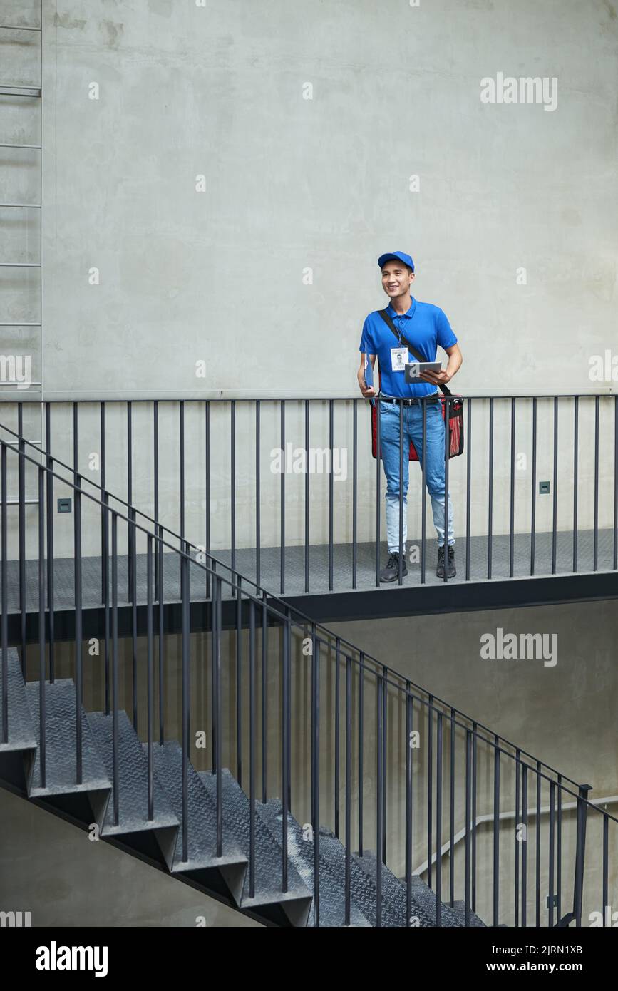 Allegro giovane corriere vietnamita con frigorifero consegna cibo Foto Stock