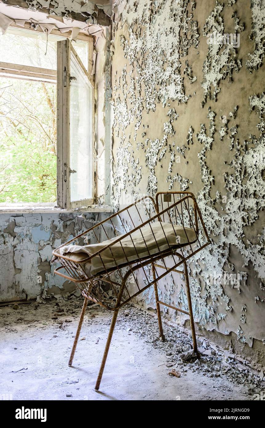 Culla singola arrugginita in una sala disgregante del reparto maternità di Prypiat, epicentro del disastro nucleare di Cernobyl in Ucraina Foto Stock