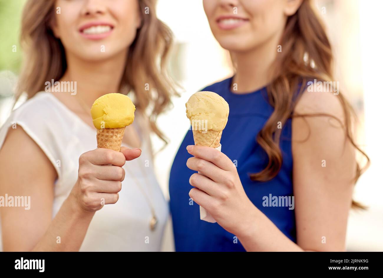 primo piano di donne felici che mangiano gelato in città Foto Stock