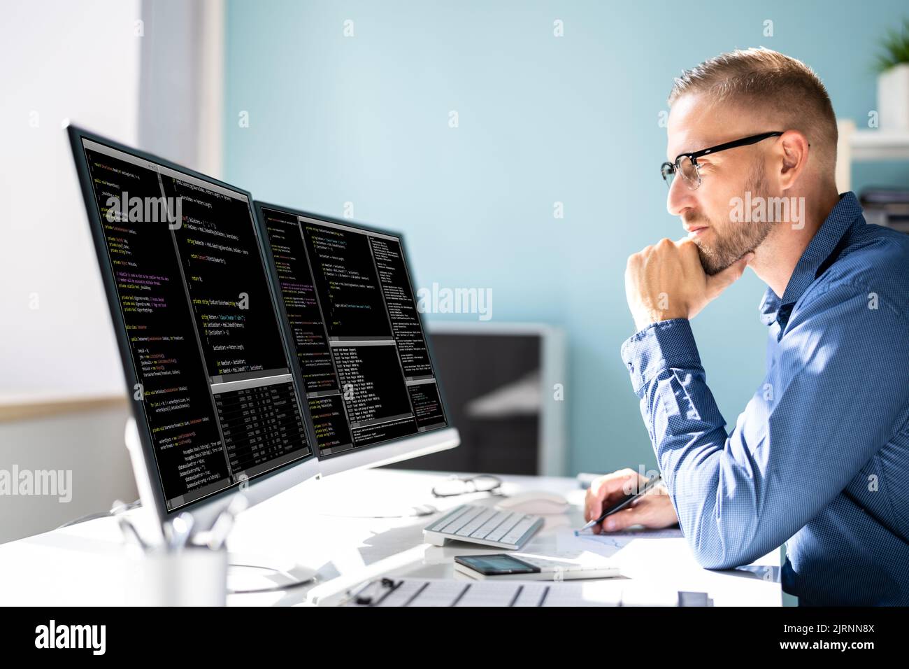 Programmatore di computer che scrive il codice di programma sul computer in Office Foto Stock